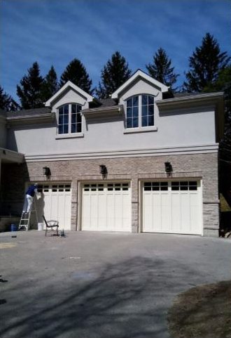 A Danyal painter finishing garage doors on a GTA home